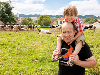 Betriebsleiter mit Kind vor Rinderweide
