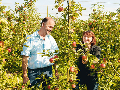 Betriebsleiter mit Frau in Apfelplantage