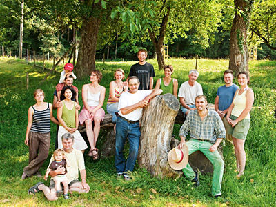 Mitglieder der Hofgemeinschaft auf Baumgruppe sitzend