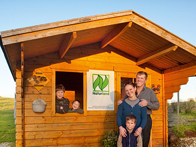 © Feneberg/Bio mit Gesicht Familie vor Hütte