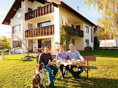 © Feneberg/Bio mit Gesicht Familie vor Wohnhaus