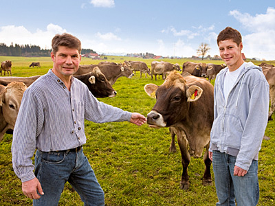 Betriebsleiter und Sohn auf Weide