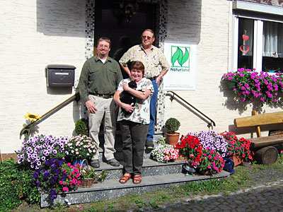 Juniorchef mit Eltern vor Wohnhaus