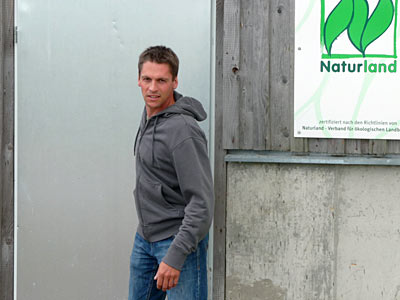 © Bio mit Gesicht Betriebsleiter vor Naturland Schild
