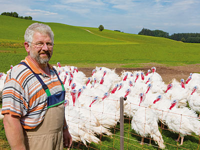 © Feneberg/Bio mit Gesicht Betriebsleiter vor der Weide mit Puten