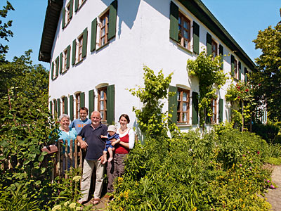 © Feneberg/Bio mit Gesicht Betriebsleiterfamilie vor Bauernhaus