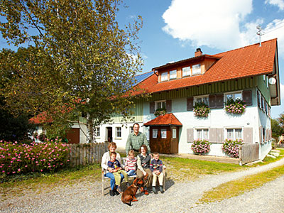 © Feneberg/ Bio mit Gesicht Betriebsleiterfamilie vor Bauernhaus