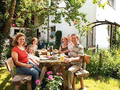 © Feneberg/Bio mit Gesicht Familie am Tisch im Garten