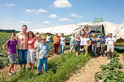 © Feneberg/Bio mit Gesicht Betriebsleiter mit Familie und Team im Gemüsefeld