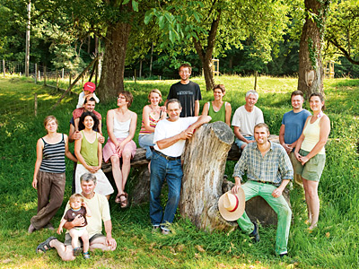 © Feneberg/Bio mit Gesicht Mitglieder der Hofgemeinschaft auf Baumgruppe sitzend