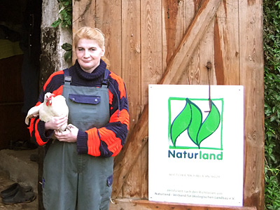 © Bio mit Gesicht Betriebsleiterin mit Huhn auf Arm