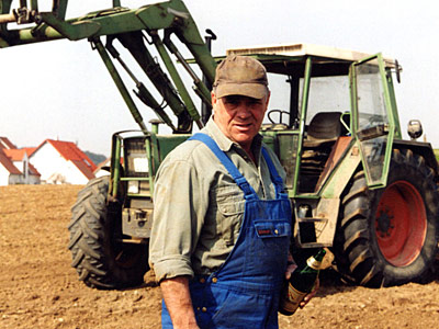 © Bio mit Gesicht Bauer vor Traktor