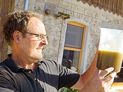 © Feneberg/Bio mit Gesicht Betriebsleiter prüft Öl im Becher