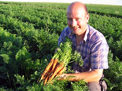 © Naturland Öko-Bauer zeigt frisch geerntete Möhren