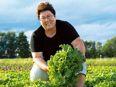 © Bio mit Gesicht Frau auf Salatfeld
